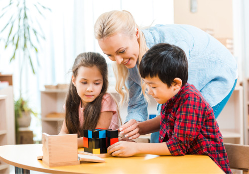 An instructor help two children during Pre-K in East Peoria IL