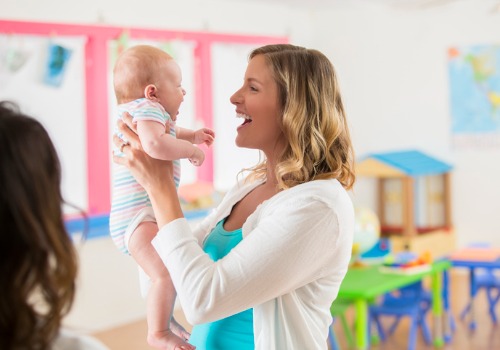 An instructor holding a baby at a Child Development Center for East Peoria IL