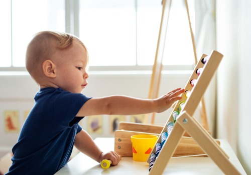 A young boy playing with an abacus at a Child Development Center for Dunlap IL