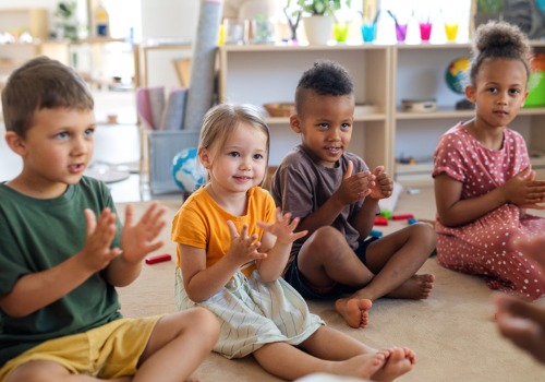Children sit in a circle, clapping and singing at PALS, an outstanding Preschool Near You