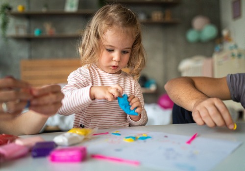 A toddler plays with blue Play dough, which is 1 of 5 Ways You Can Begin Teaching Fine Motor Skills at Home