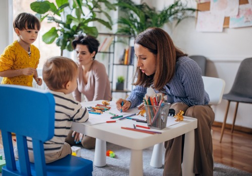 A teacher works with children on artwork at PALS Childcare Development Center for East Peoria IL residents