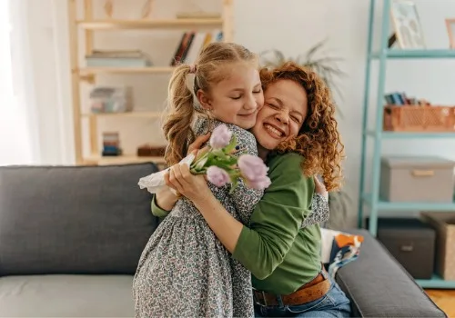 A woman hugs her daughter after receiving flowers as one of many Random Acts of Kindness.