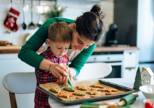 A mother decorates Christmas cookies with her son as part of building new routines during the holidays